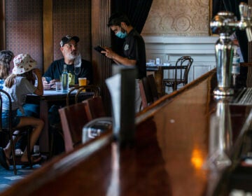 A waiter takes the order of customers inside a restaurant
