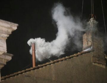 white smoke coming out of a chimney at night
